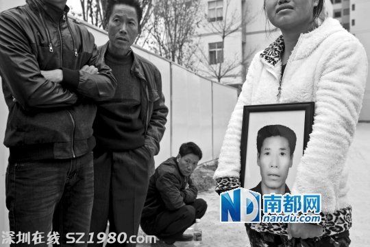 在新塘派出所門口，女兒拿著父親劉先生的遺像為其討公道。 南都記者 黎湛均 攝