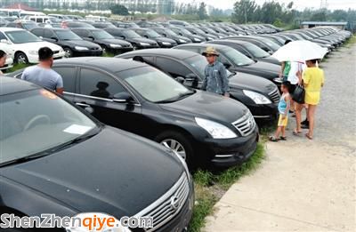 昨日，市民在山東棗莊一家拍賣公司場地上查看待拍賣公車。當(dāng)日，棗莊市103輛公車公開拍賣。新華社記者 馮杰 攝