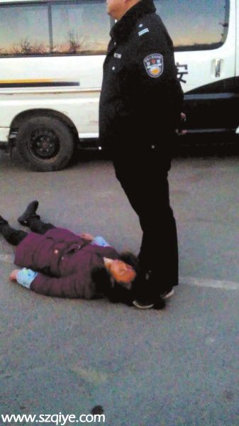 事發(fā)現(xiàn)場一名身穿警服的男子疑似用腳踩著女農(nóng)民 工周秀云的頭發(fā)（12月13日攝）。