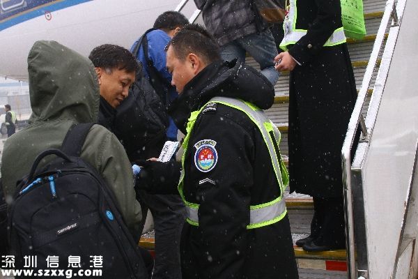 圖：監(jiān)護員認(rèn)真查驗登機牌